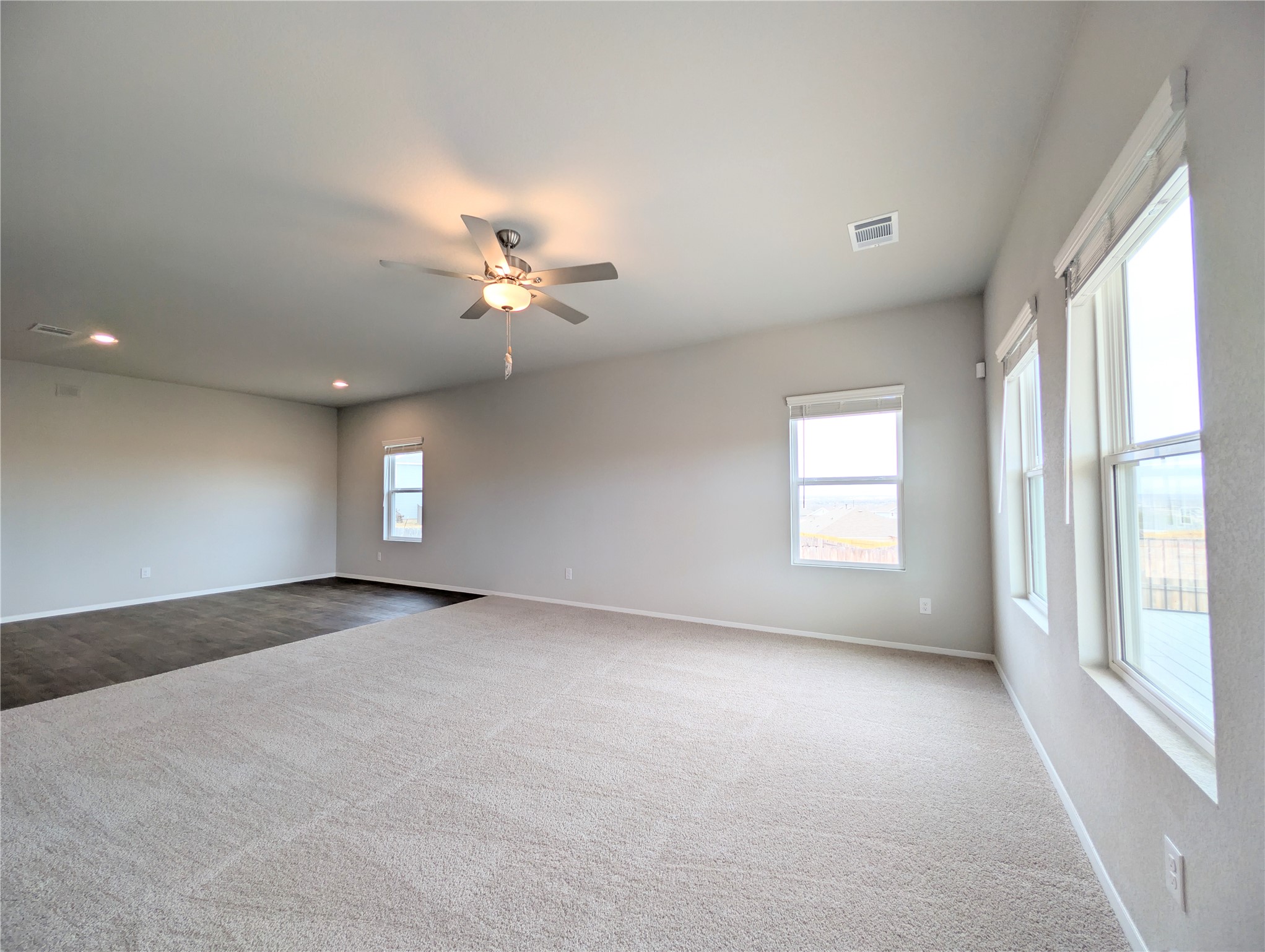 5524 Sacra Cove Austin, TX 78747 - Photo 5 of 37 Carpeted living room with a ceiling fan and recessed lighting
