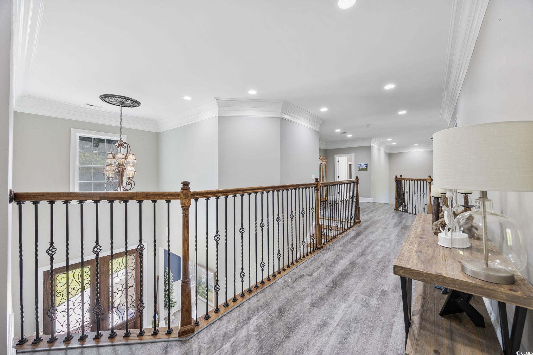 2273 Starduster Lane Little River, SC 29566 - Photo 18 of 40 Hallway featuring crown molding, recessed lighting, wood finished floors, an upstairs landing, and a chandelier