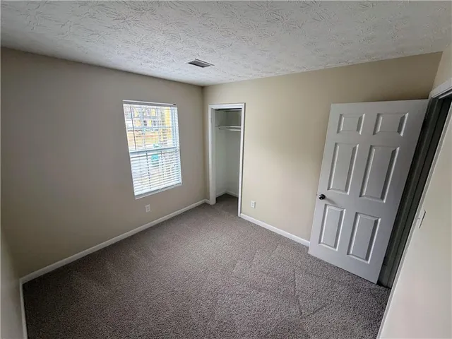 an empty room with closet and windows