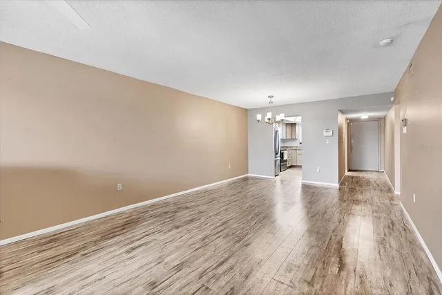 a view of a big room with wooden floor and windows