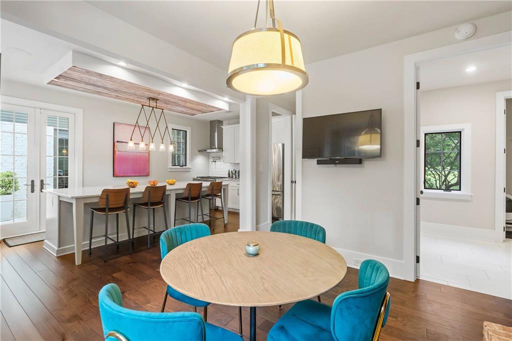 7255 Old Rico Road Chattahoochee Hills, GA 30268 - Photo 21 of 78 a dining room with wooden floor a chandelier a wooden table and chairs