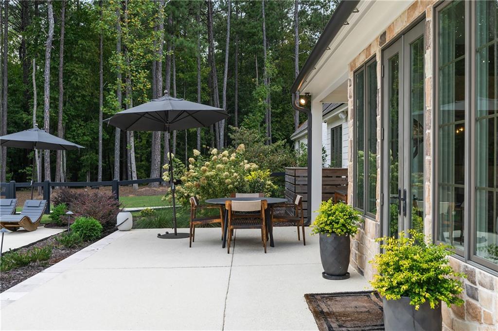 7255 Old Rico Road Chattahoochee Hills, GA 30268 - Photo 61 of 78 a view of a chair and table under an umbrella in patio of a house