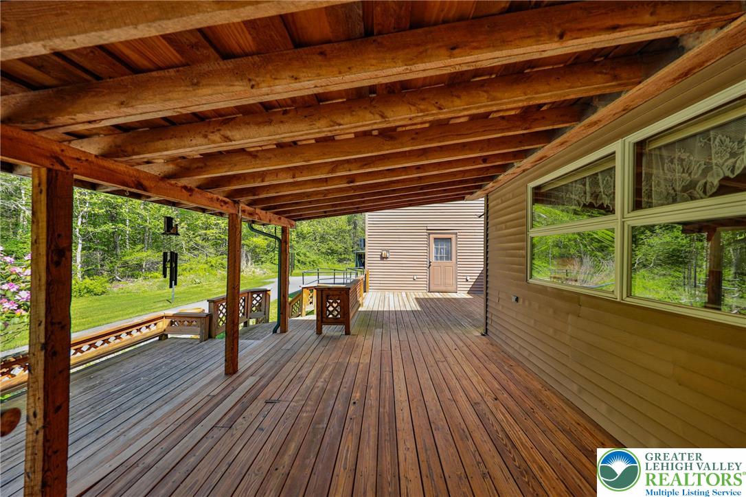 331 Cranberry Creek Road Cresco, PA 18326 - Photo 87 of 95 A spacious wood deck offers covered outdoor living, perfect for enjoying the surrounding nature.
