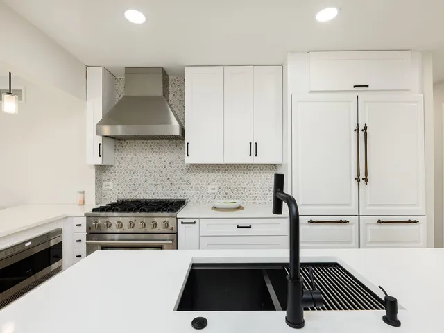 a kitchen with a sink a stove and cabinets