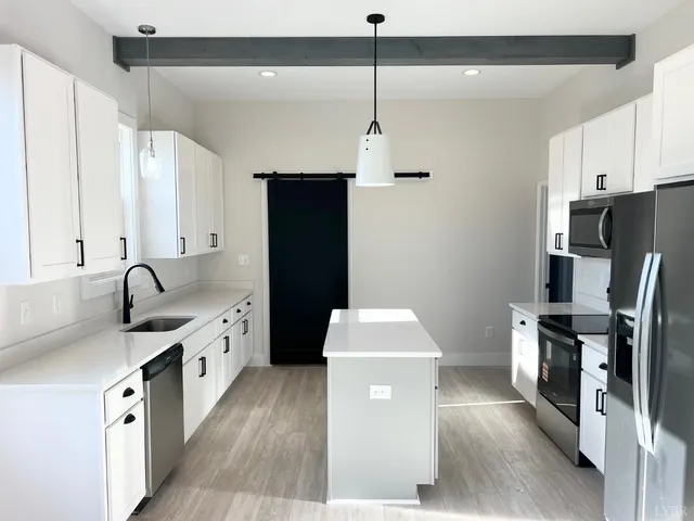 a kitchen with granite countertop a sink a stove and a refrigerator
