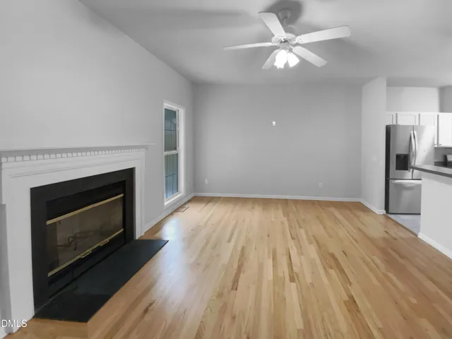 a view of empty room with wooden floor and fireplace