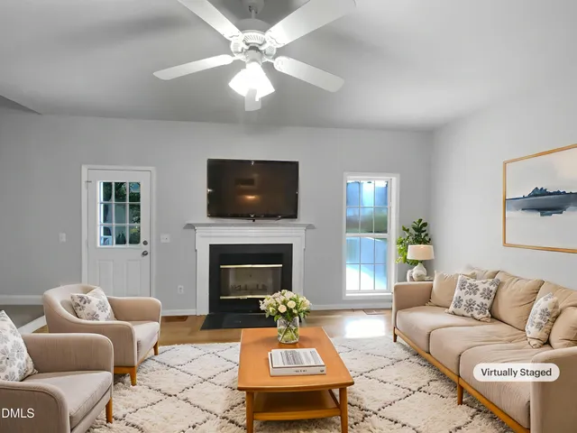 a living room with furniture a fireplace and a flat screen tv