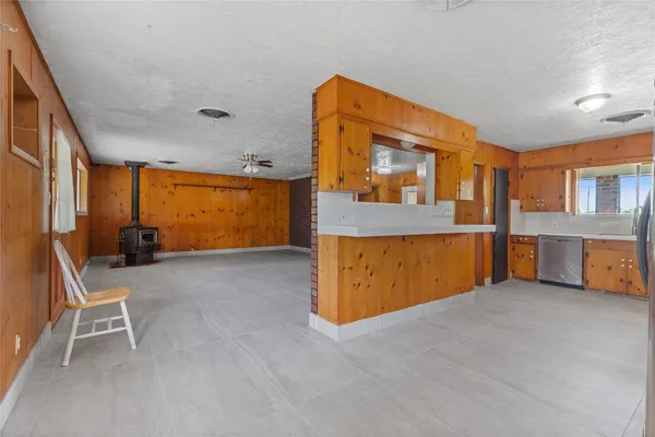 an empty room with windows and ceiling fan