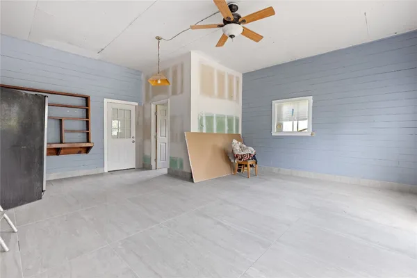 an empty room with a window and a fan