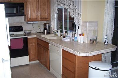 4813 Burlington Street Santa Rosa, CA 95405 - Photo 12 of 12 a kitchen with stainless steel appliances granite countertop a sink a stove and a microwave