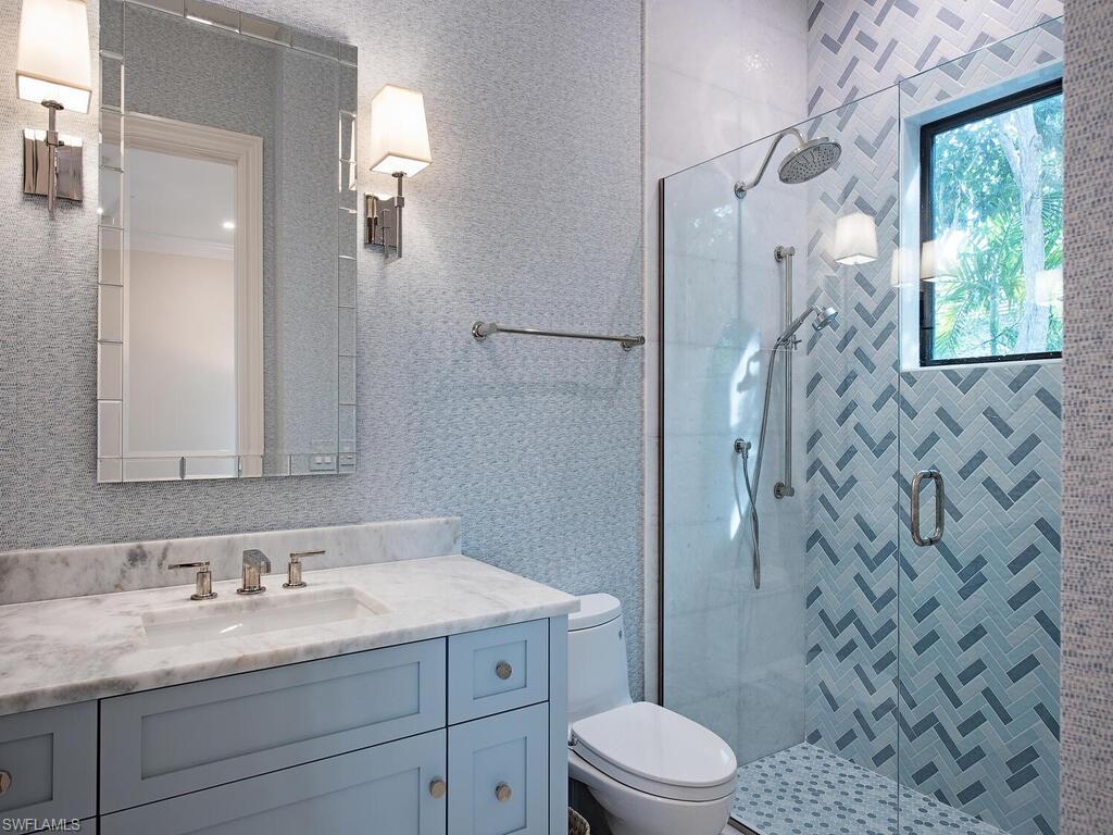 2375 Lantern Lane Naples, FL 34102 - Photo 14 of 45 a bathroom with a granite countertop sink toilet and shower