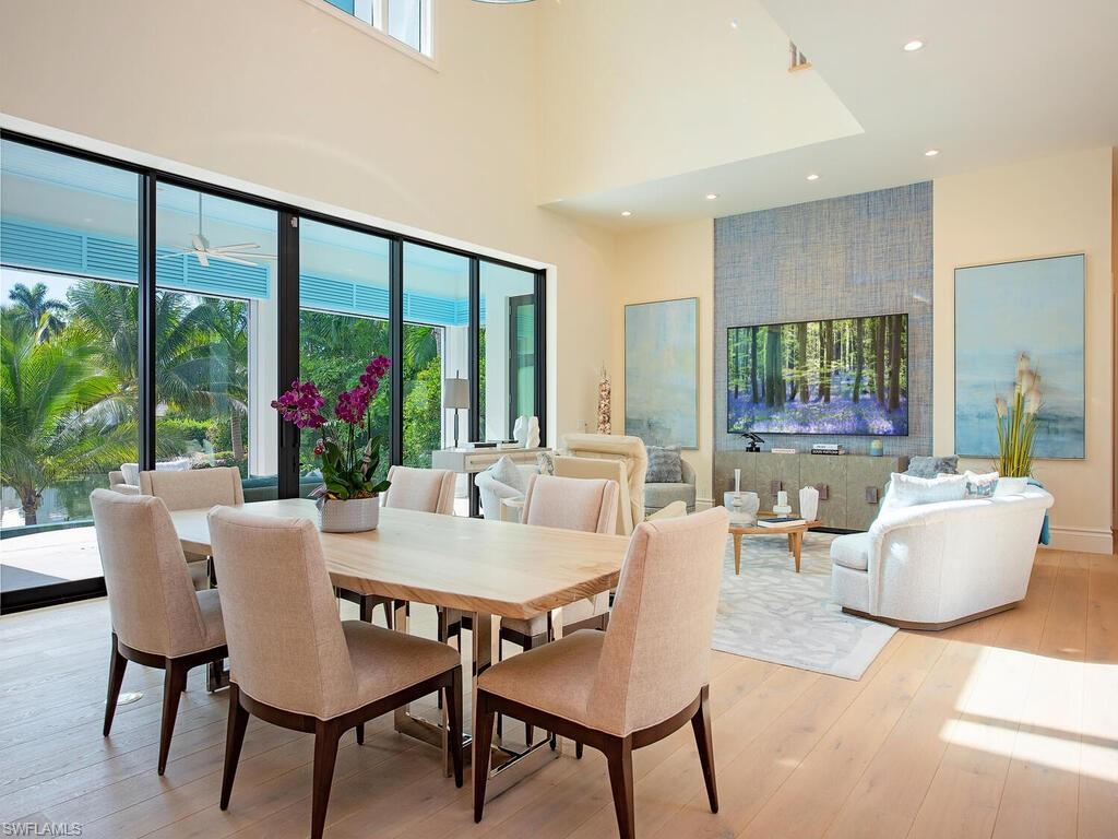 2375 Lantern Lane Naples, FL 34102 - Photo 6 of 45 a view of a dining room with furniture large windows and wooden floor