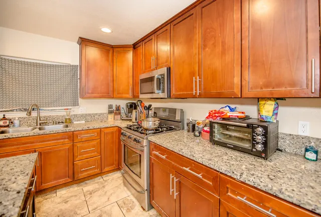 a kitchen with a sink a counter top space a stove and cabinets