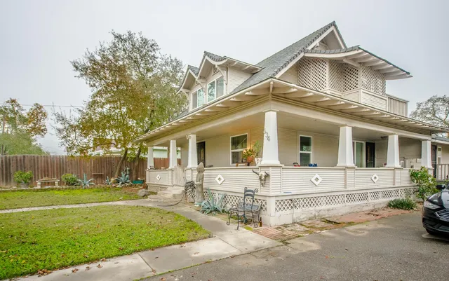 a view of a house with backyard and trees in the background