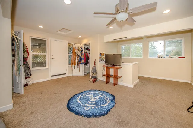 a living room with furniture a rug and white walls