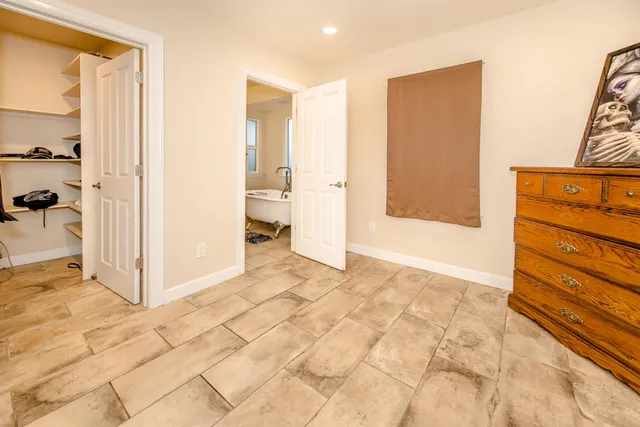 a view of backyard with small garden and wooden fence