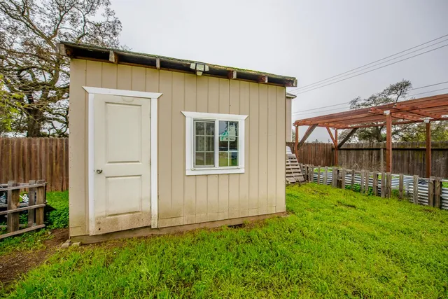 a view of a house with a small yard and wooden fence