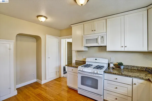 a kitchen with white cabinets and white appliances