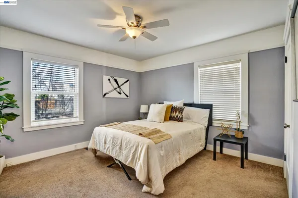 a bedroom with a bed chandelier and a window