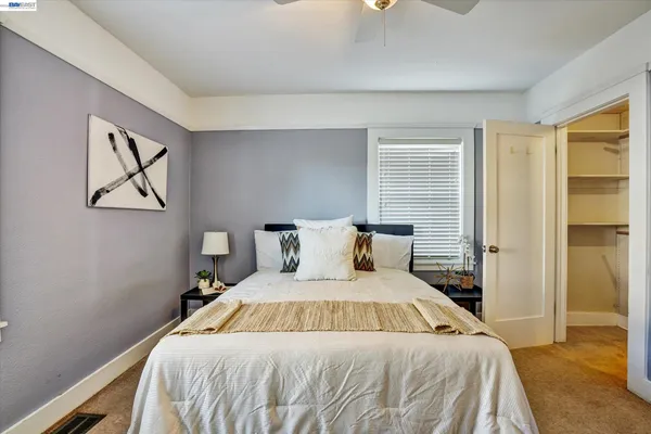 a bed sitting in a bedroom next to a window