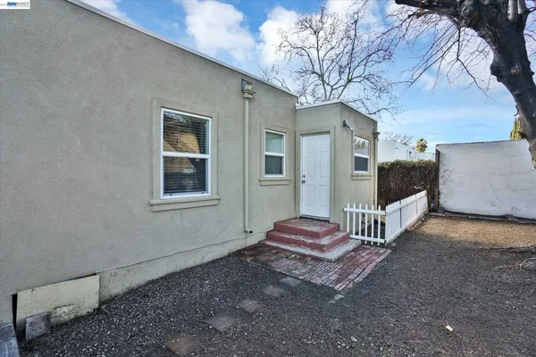 a view of a house with backyard and wooden fence