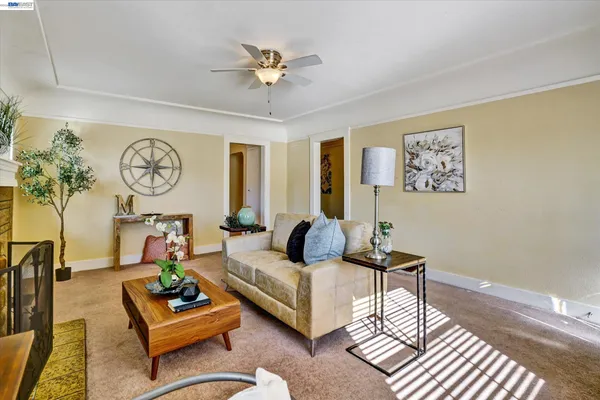 a living room with furniture a clock on wall and a window