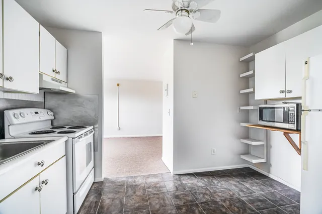 a kitchen with stainless steel appliances a stove a sink and white cabinets