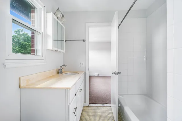 a bathroom with a sink a vanity and a bathtub