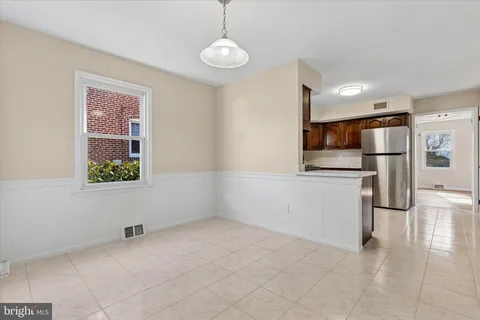 a view of kitchen with furniture refrigerator and window