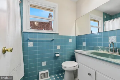 a bathroom with a sink a toilet and a mirror