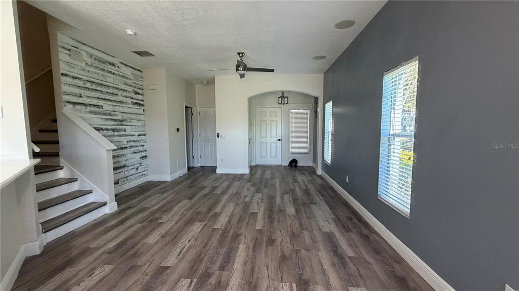 1941 Brancaster Circle Ocoee, FL 34761 - Photo 6 of 33 a view of a hallway with wooden floor and stairs