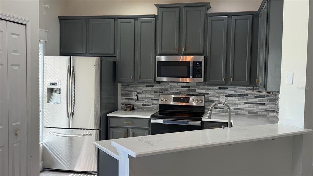1941 Brancaster Circle Ocoee, FL 34761 - Photo 7 of 33 a kitchen with a refrigerator stove and microwave
