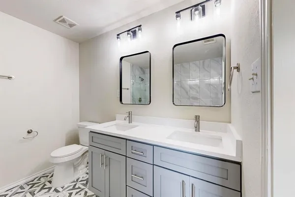 a bathroom with a toilet sink and mirror