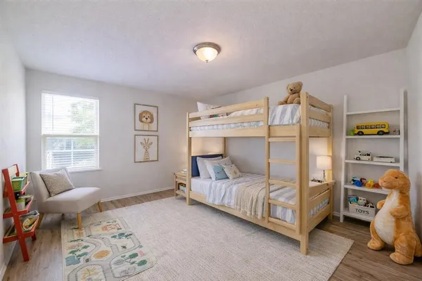a bedroom with a bed and wooden floor