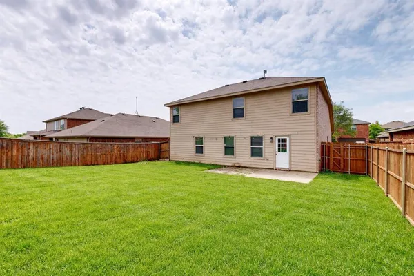 a backyard of a house with table and chairs