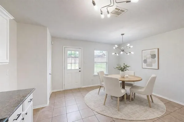 a dining room with wooden floor a chandelier a wooden table and chairs