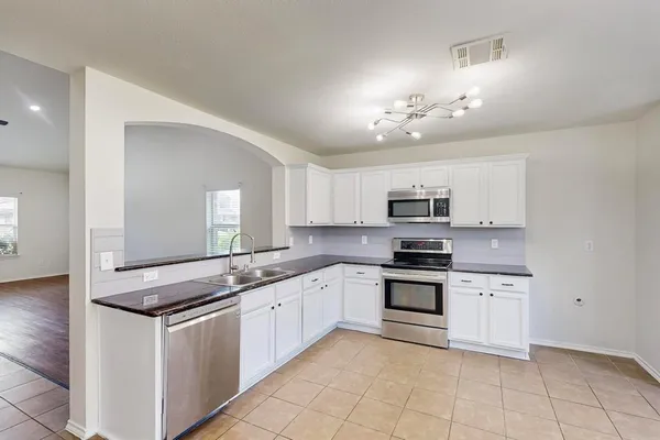 a kitchen with stainless steel appliances granite countertop a stove and a sink