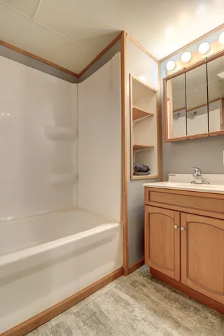 a bathroom with a granite countertop sink mirror and a bathtub