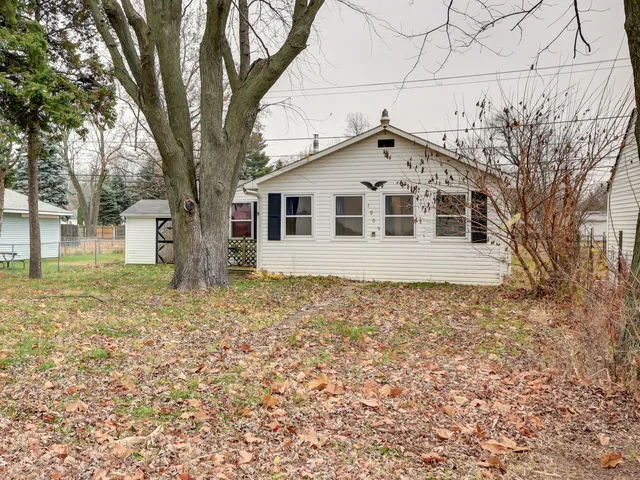 a front view of a house with a garden and trees