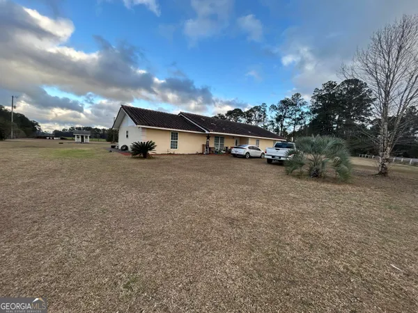 a view of a house with a yard and sitting area