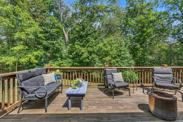 a view of deck with furniture and trees