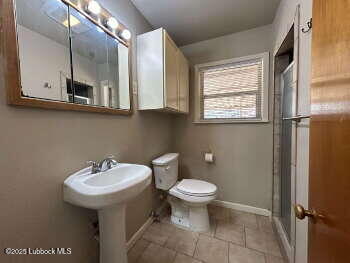 8302 Interstate 27 Lubbock, TX 79423 - Photo 13 of 21 a bathroom with a sink a mirror and a toilet