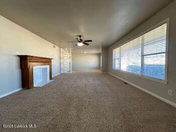 8302 Interstate 27 Lubbock, TX 79423 - Photo 3 of 21 a view of an empty room with a fireplace and a window