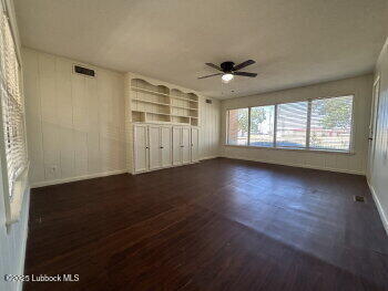 8302 Interstate 27 Lubbock, TX 79423 - Photo 9 of 21 an empty room with wooden floor and windows