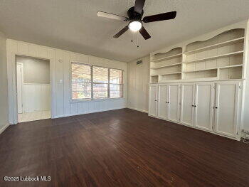 8302 Interstate 27 Lubbock, TX 79423 - Photo 10 of 21 an empty room with wooden floor chandelier fan and windows
