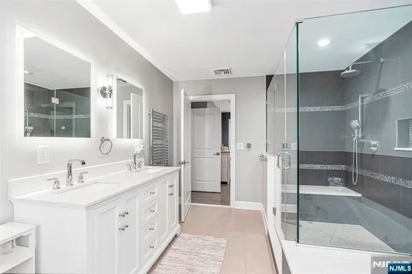 a spacious bathroom with a double vanity sink mirror double and shower