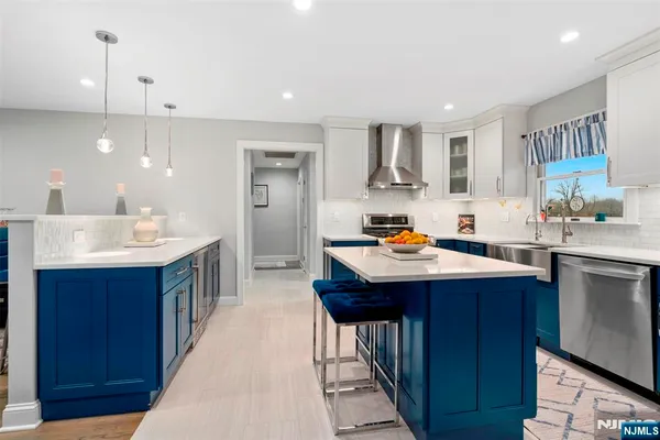 a kitchen with kitchen island granite countertop a sink appliances and cabinets