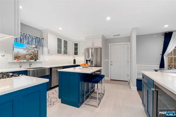 a kitchen with kitchen island a sink stove and refrigerator