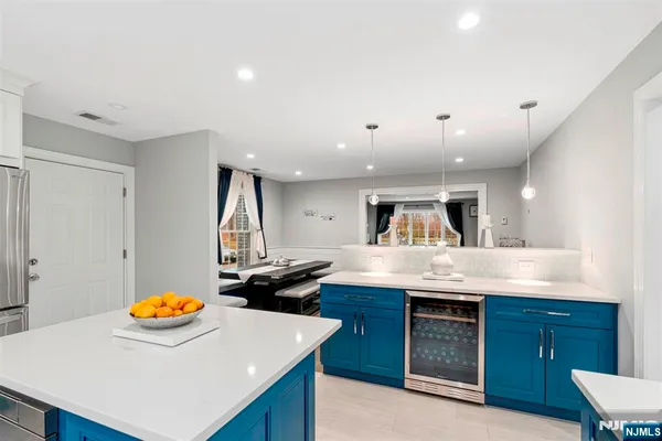 a kitchen with stainless steel appliances a stove a refrigerator a oven a dining table and chairs