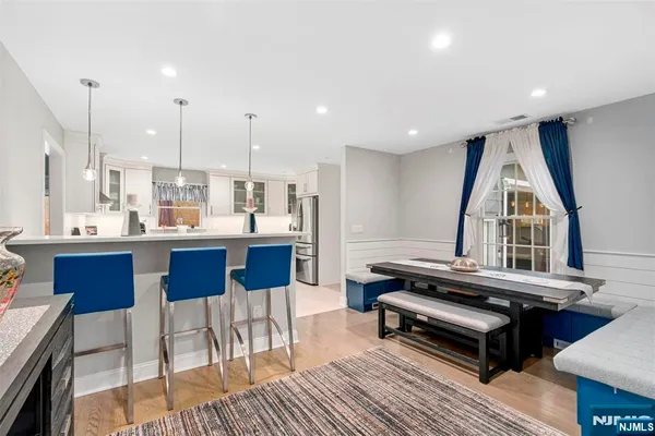 a living room with stainless steel appliances kitchen island granite countertop furniture and a wooden floor